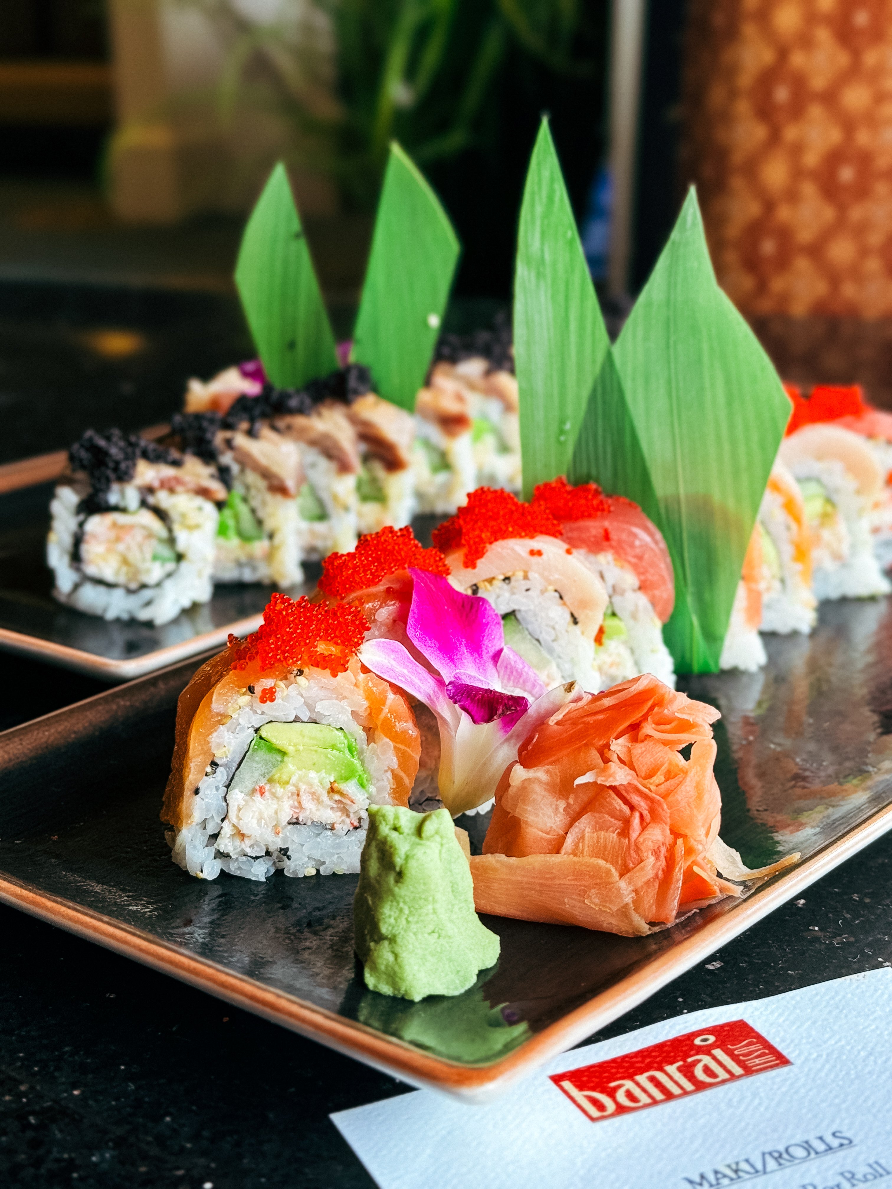 A dish of colorful sushi at Banrai Sushi plated with leafy garnishes. 