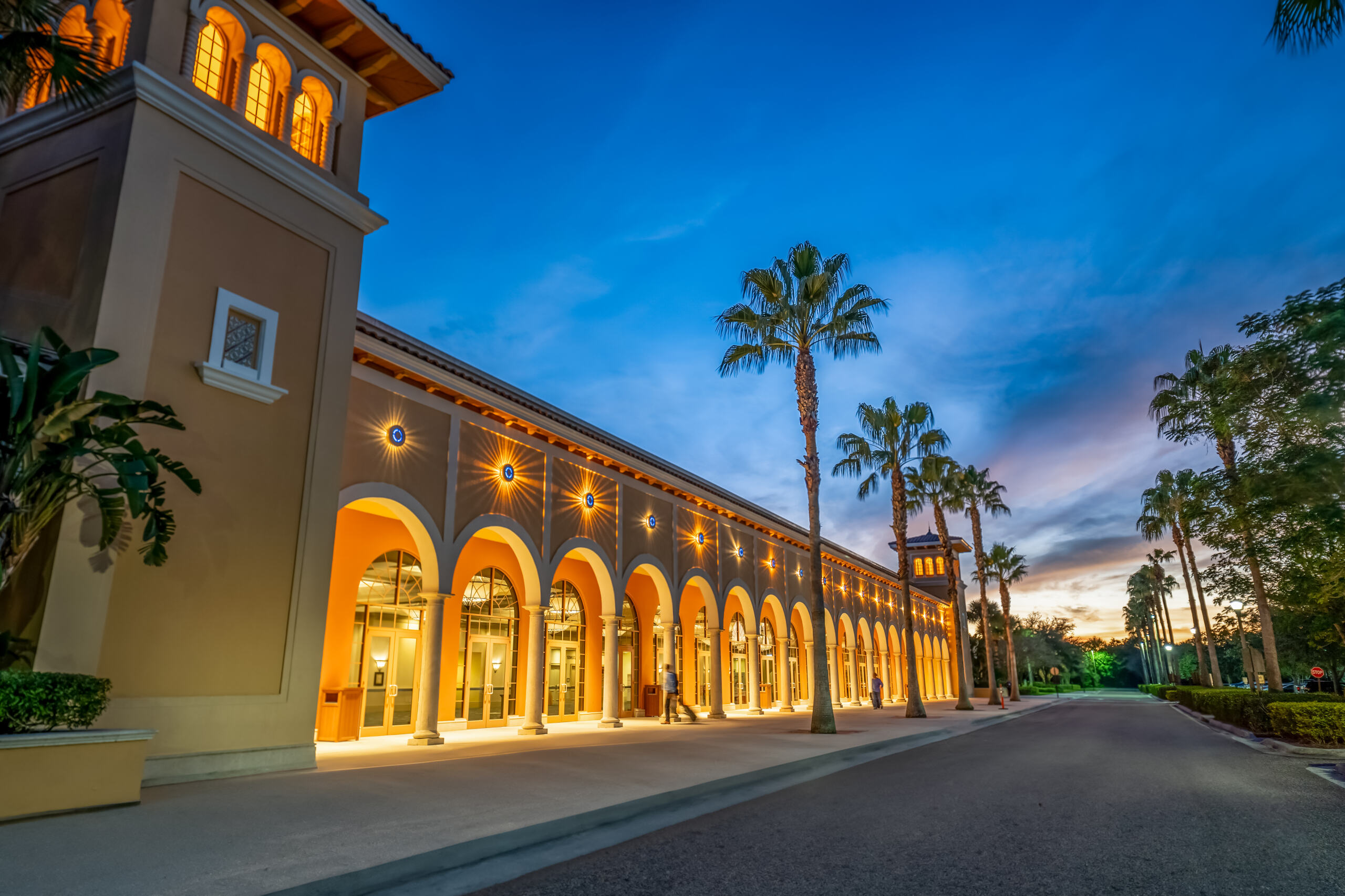 A long row of arched doorways glows at dusk. 